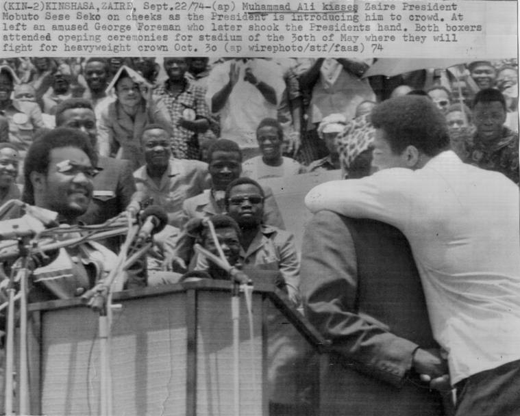 Kinshasa, 22 settembre 1974: il presidente dello Zaire Mobutu abbraccia Muhammad Ali sotto lo sguardo divertito di George Foreman (Ap)
